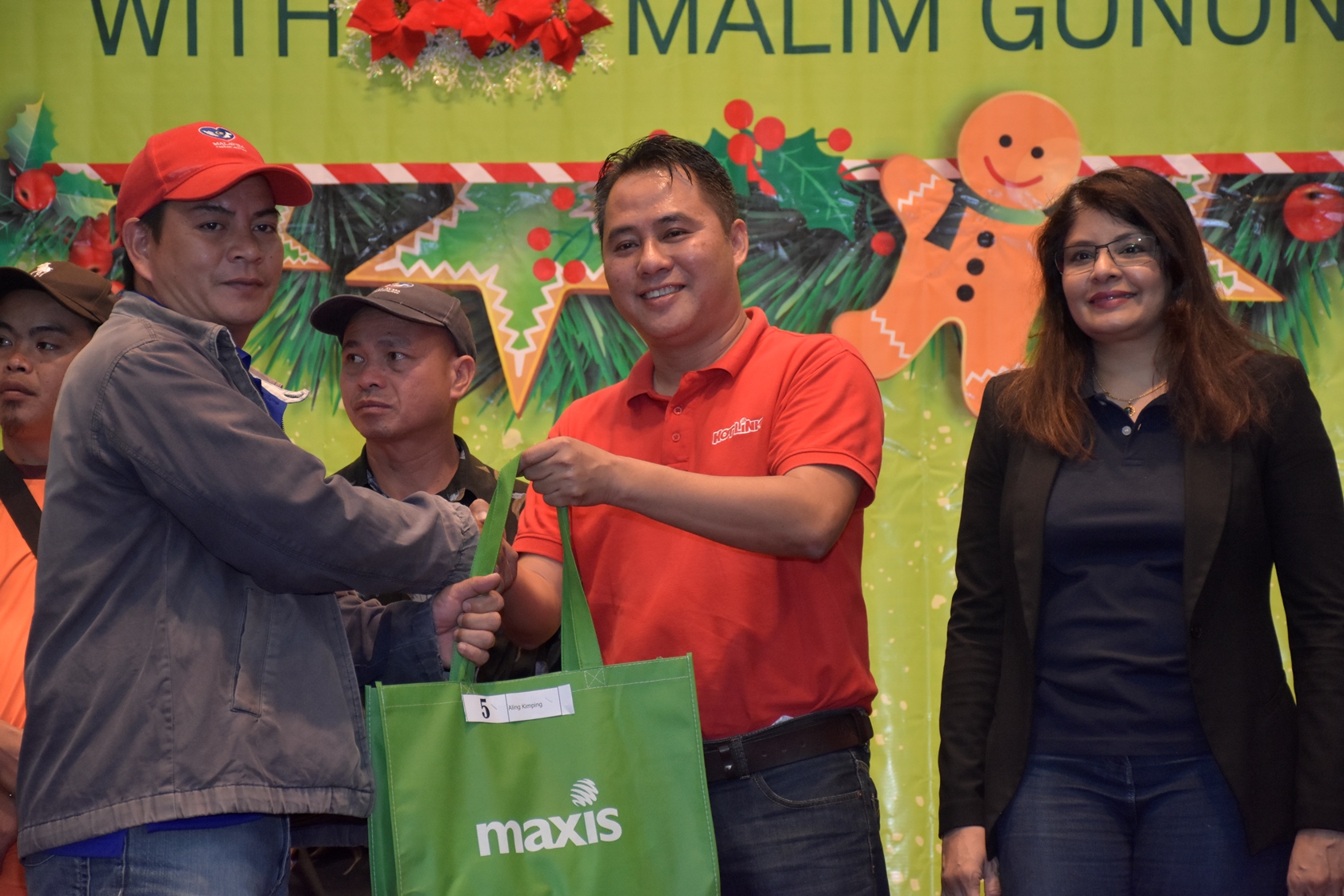 Photo 3: Maxis distributed school uniforms for the children of the mountain guides during the event. (From right - Mariam Bevi Batcha, Head of Corporate Affairs and Melvin Jeffrine Mojinun, Maxis Head of Sabah Region)