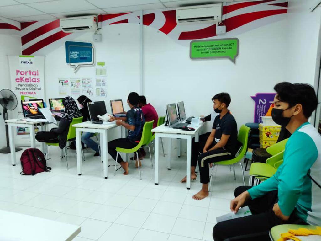A group of students attending the clinic at their Pusat Internet, joining via Zoom